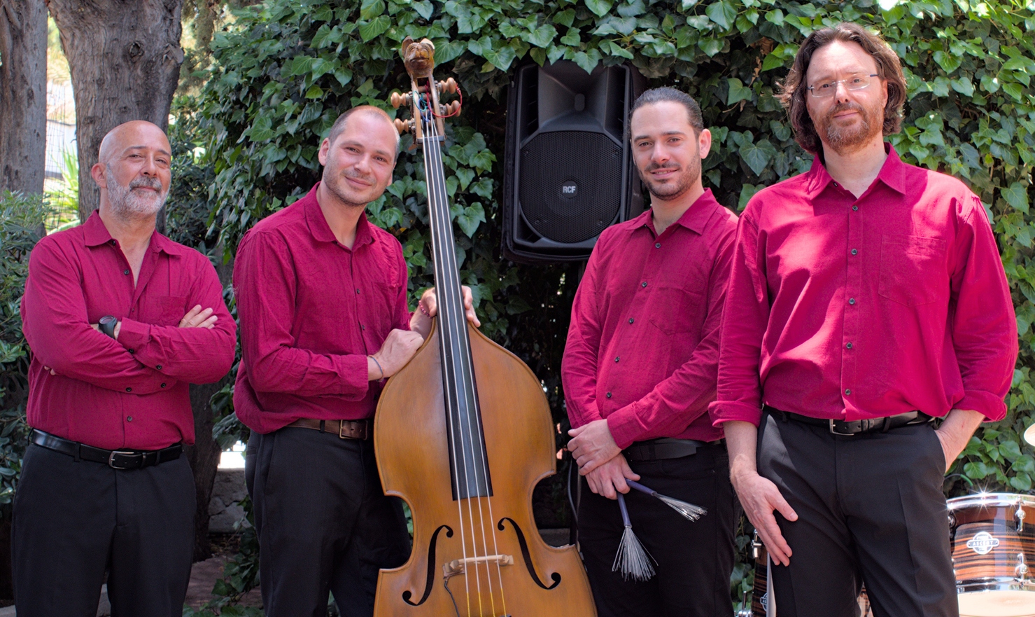 Sarabanda in quartetto con contrabbasso, foto posata. In camicia rossa e pantaloni neri. Sul set del video di LOVE 