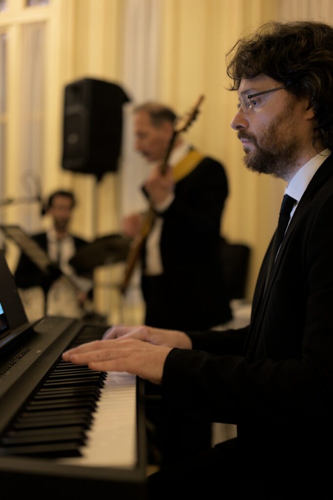 Roberto Mezzatesta in primo piano, la sezione ritmica sfocata sullo sfondo, suonano a VIlla Igiea