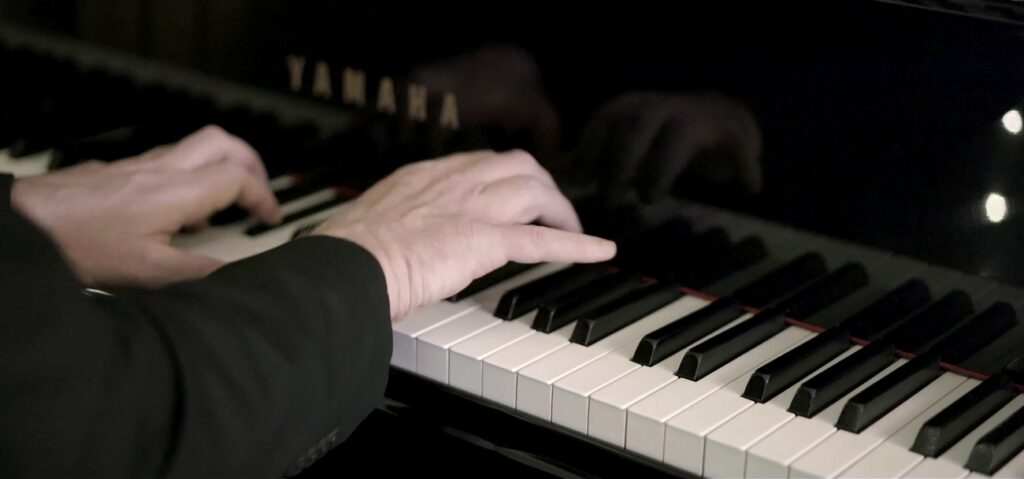 dettaglio delle mani del pianista durante la registrazione in studio di via con me di Paolo Conte
