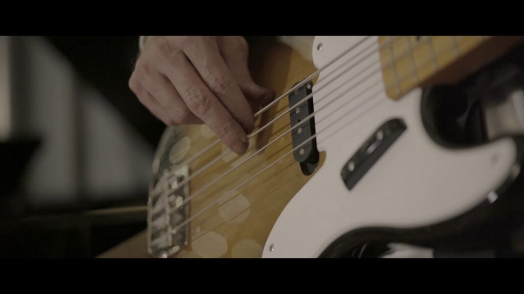 dettaglio delle mani del bassista sulle corde del basso elettrico. Durante la ripresa del video "meraviglioso Amore mio" di Arisa