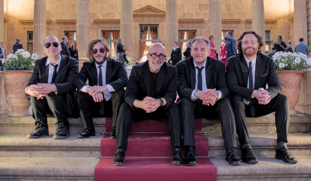 Sarabanda foto ufficiale del quintetto con sax, seduti sulla scalinata di Palazzo Villarosa a Bagheria.