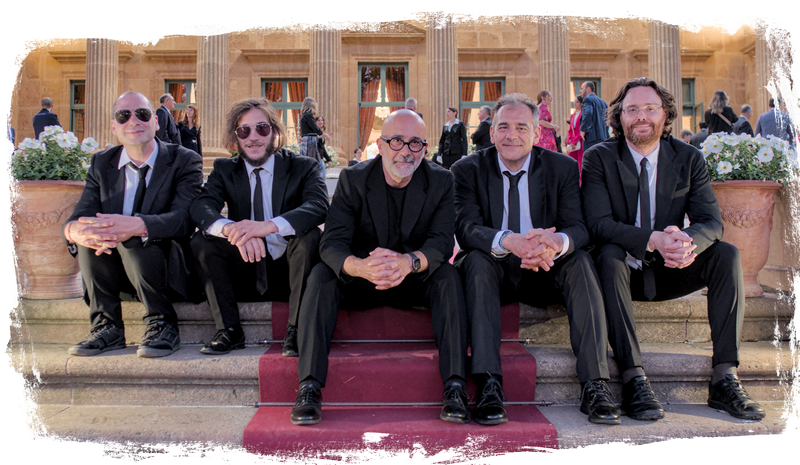 Sarabanda foto ufficiale del quintetto con sax, seduti sulla scalinata di Palazzo Villarosa a Bagheria. Foto effetto grunge