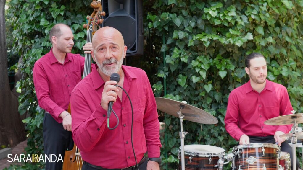 Samaritano durante le riprese di LOVE, mezzo busto, alle sue spalle contrabbasso e batteria