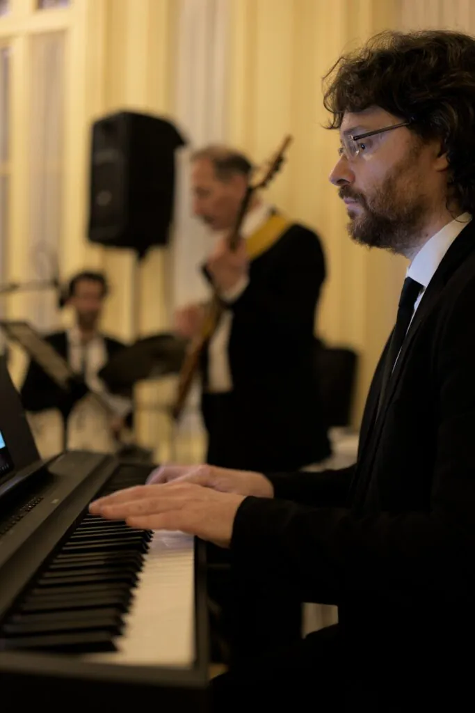 Roberto Mezzatesta in primo piano, la sezione ritmica sfocata sullo sfondo, suonano a VIlla Igiea